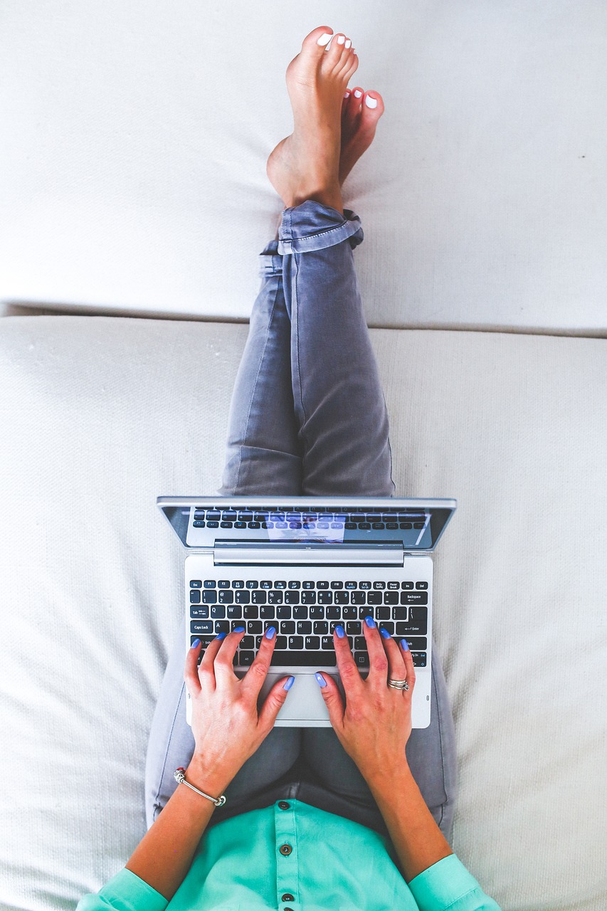 Person auf der Couch mit Laptop
